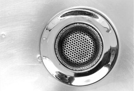 Plunger - a close up of a metal sink drain