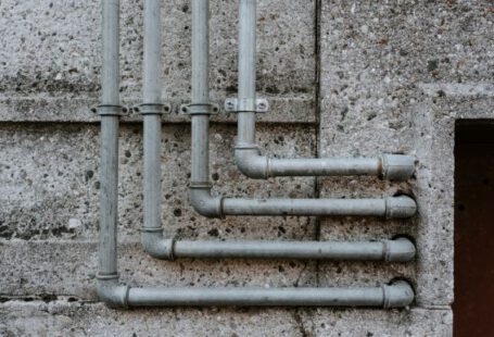 Plumbing - white metal pipe on gray concrete wall