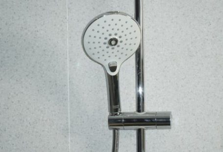 Shower - stainless steel shower head on white ceramic tiles