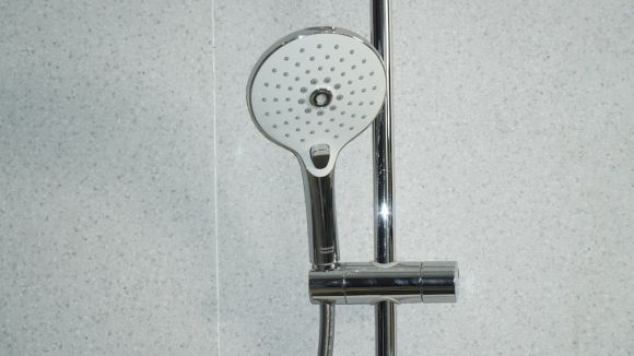 Shower - stainless steel shower head on white ceramic tiles