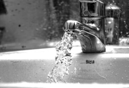 Faucet - water falling from faucet in grayscale photography