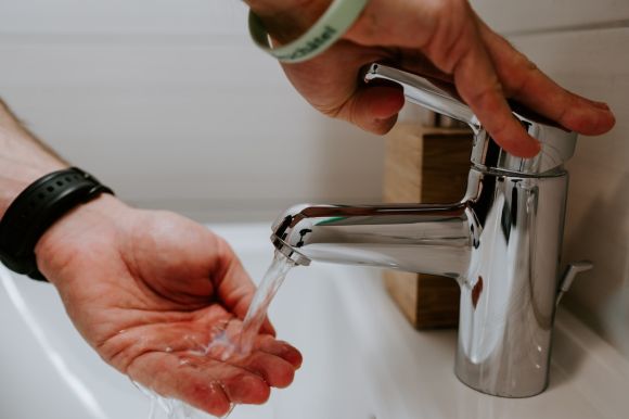 Faucet - person holding stainless steel faucet