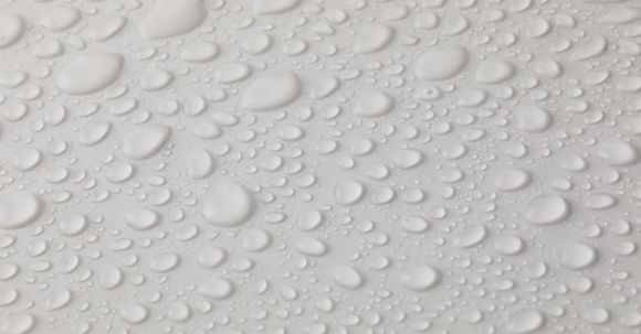 Water Heater Leaks - Closeup top view of plain wet abstract surface with small dripped water drops of different shapes placed on white background