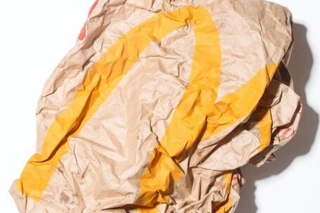 Garbage Disposal - Top view of crumpled empty craft paper bag of fast food restaurant placed on white background illustrating recycle garbage concept