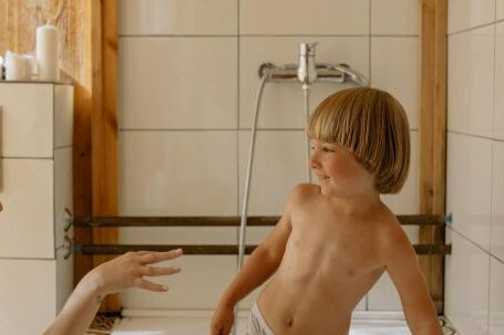 Bathroom Upgrades - Topless Boy in White Shorts Standing on White Ceramic Sink
